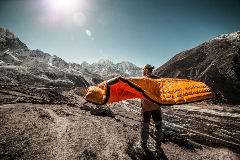 Hiker airing out a down sleeping bag on the mountain trail — essential sleeping bag care on a multi-day trek to Everest Base Camp. What sleeping bag for the EBC trek will you take?